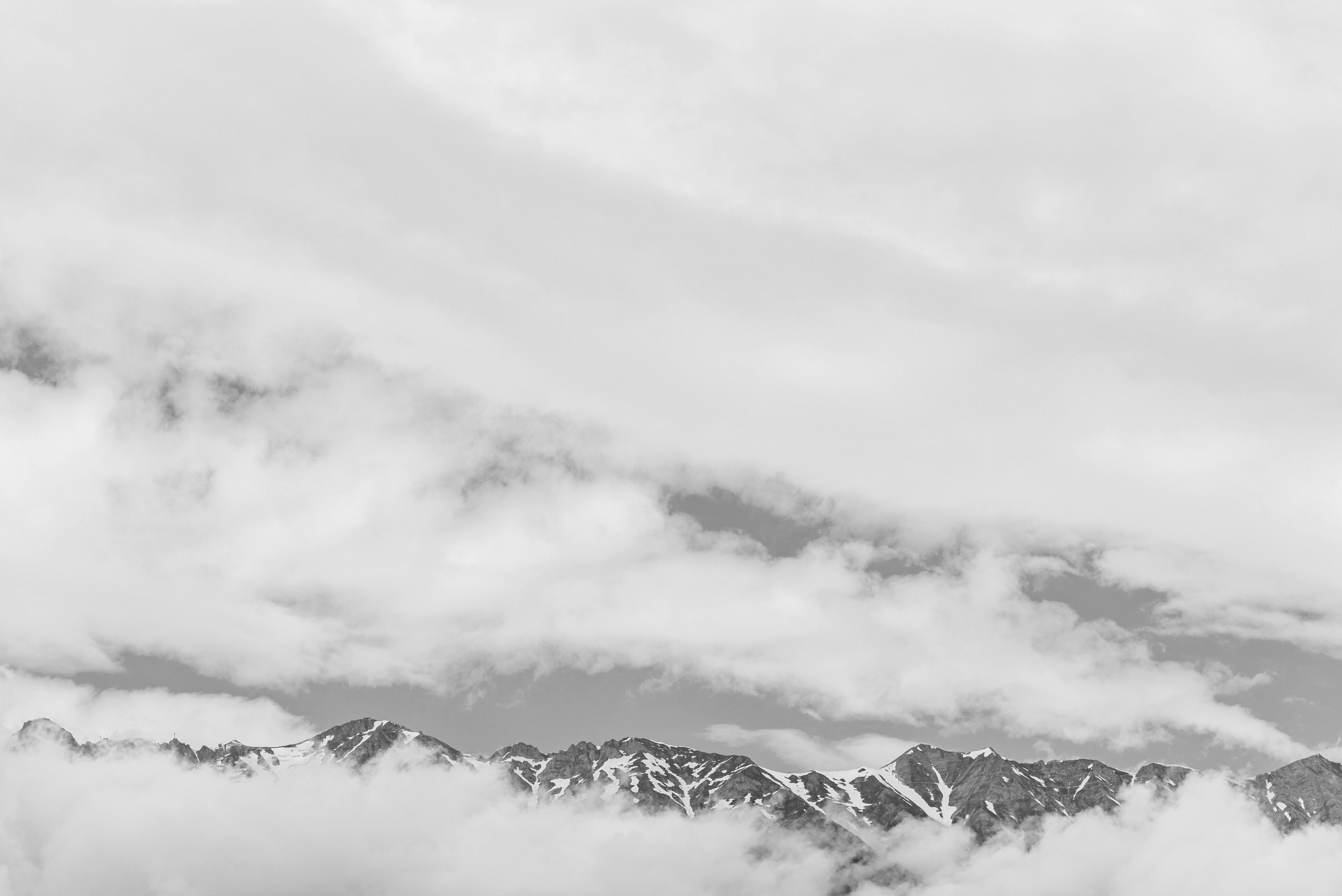 snow covered mountain under cloudy sky during daytime